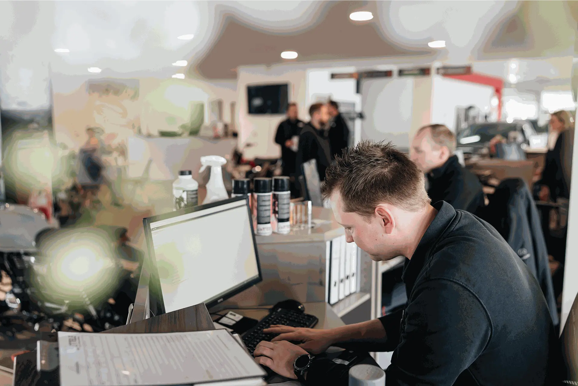 Ein Mitarbeiter vor dem Monitor im Autohaus